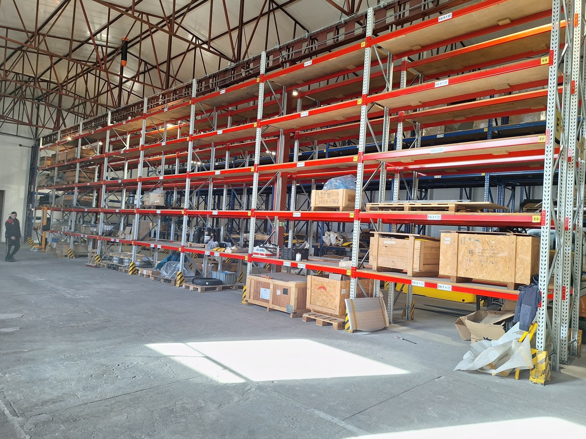 Multi-tier rack walls stacked with rail-grade components across the full warehouse floor