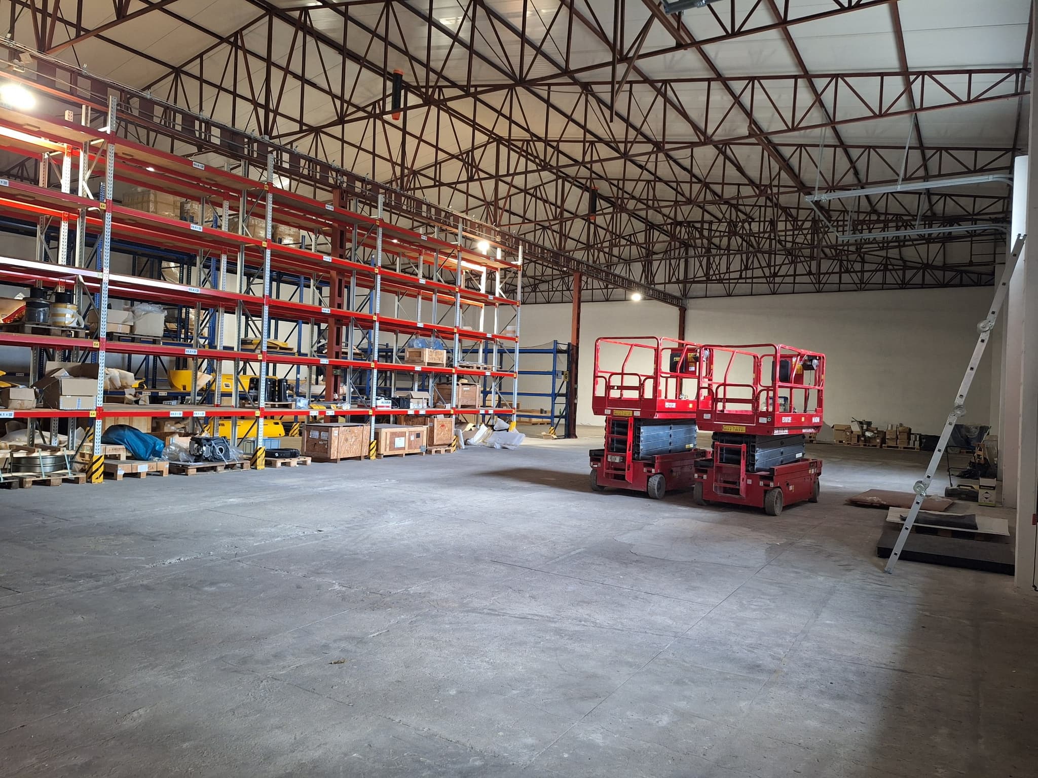 Technician on a scissor lift accessing upper rack tiers to verify component inventory